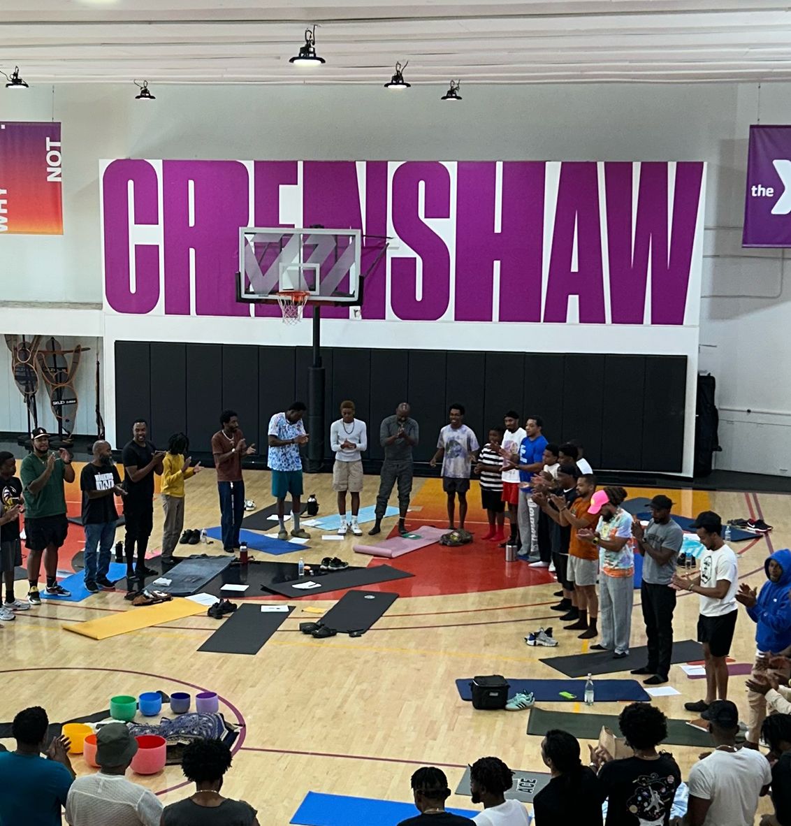 Young men and mentors gathered in a circle for a wellness session at the Crenshaw YMCA